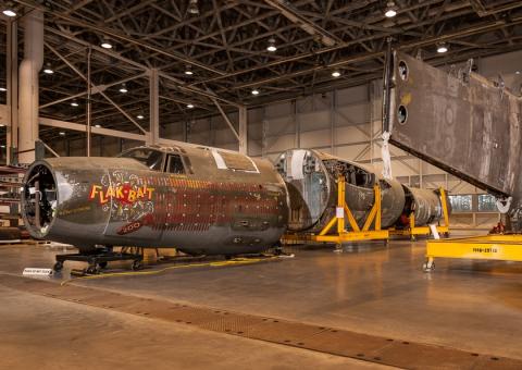 Large building with parts of an airplane on mobile stands