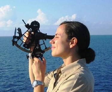 Woman with sextant beside a body of water